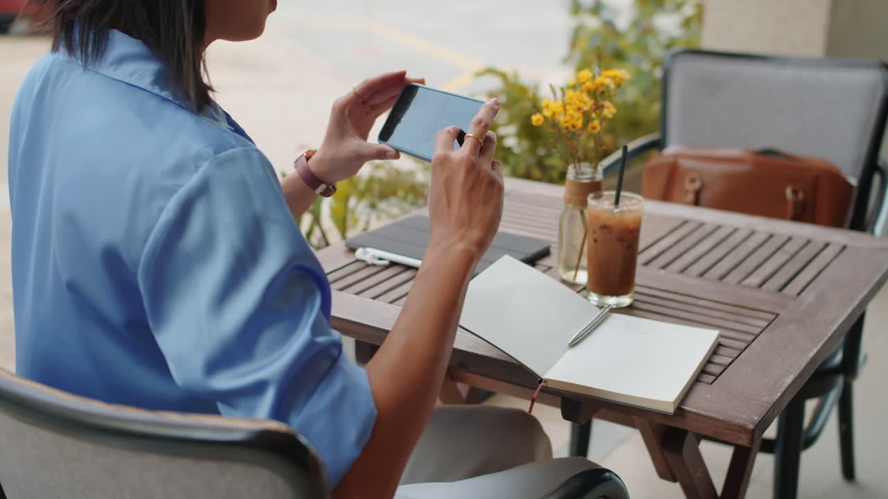 Female Freelancer Taking Photo of Workspace in Cafe