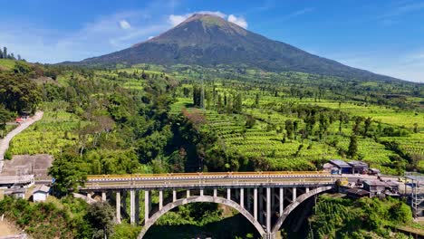 aerial view of the sigandul bridge and mount sindoro in the background