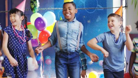 animation of gold confetti over diverse happy children having fun dancing at party