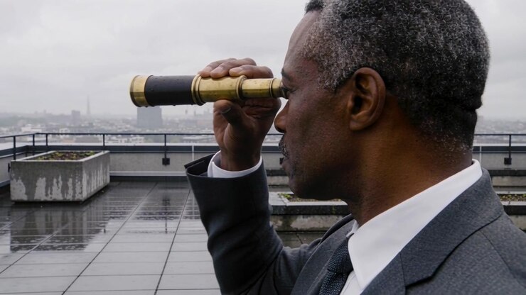 Uomo d'affari che impugna un cannocchiale in ottone mentre scruta lo skyline nebbioso da una terrazza sul tetto, generato dall'IA