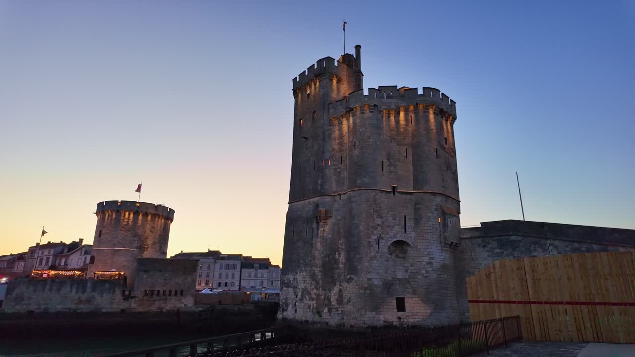 The Chain Tower of coastal fortress lit by sunset in European city harbor of La Rochelle, Nouvelle-Aquitaine, France