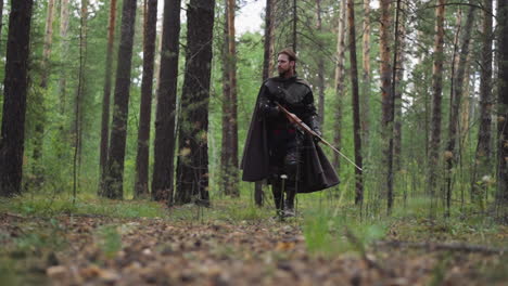 brave military man with cape and bow patrols dense forest