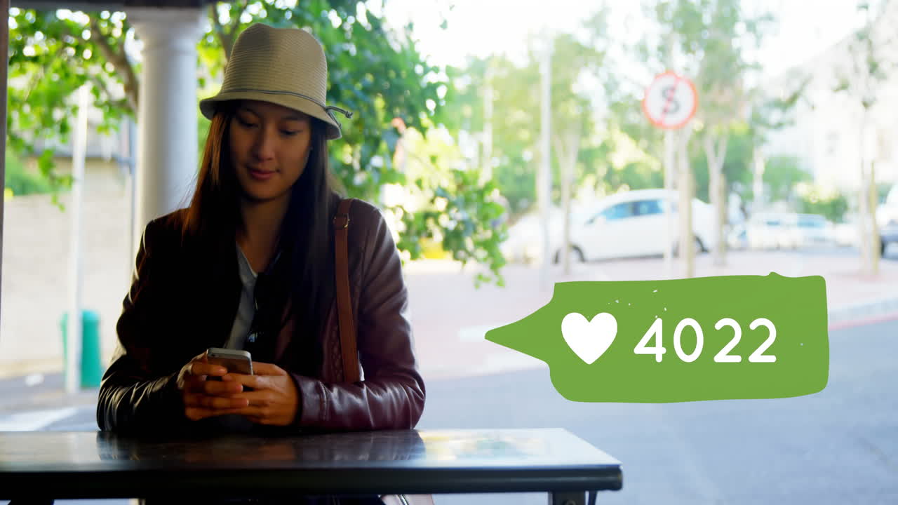 mujer sentada en una mesa mientras envía mensajes de texto 4k