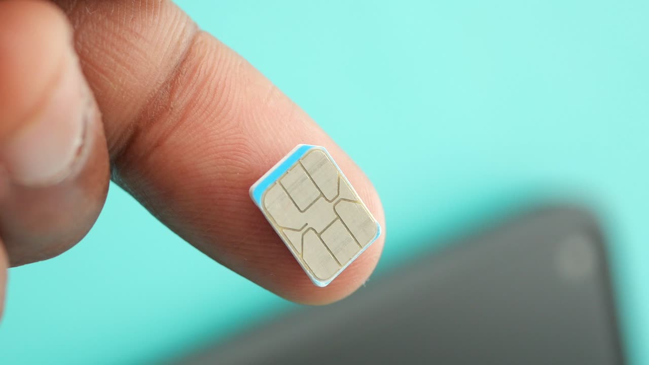Close-up of a SIM card on a fingertip