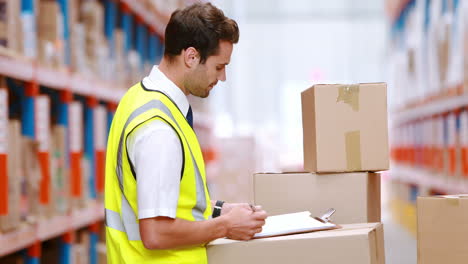 Warehouse-worker-writing-on-clipboard