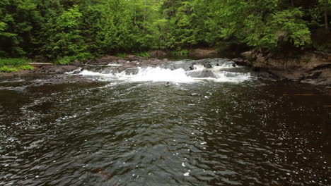 drone image following the current at oxtongue falls at algonquin park, ontario - canada