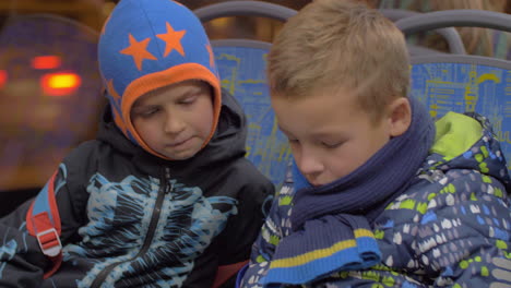 Two-young-boys-riding-on-public-transportation