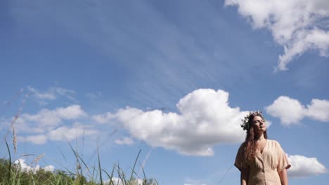 a woman enjoying summer with her flower wreath and the sky in the background, natural colours, slow motion