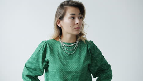 woman in a green polka dot shirt with chains