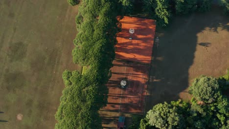 top view of empty tennis courts with streaks of sunlight and tree shadows at the park in the island of brijuni in croatia