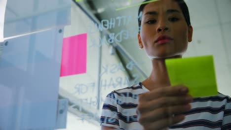 Female-executive-looking-at-sticky-notes