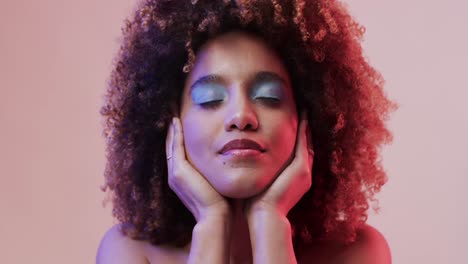 happy biracial woman with dark hair in blue and pink light, slow motion