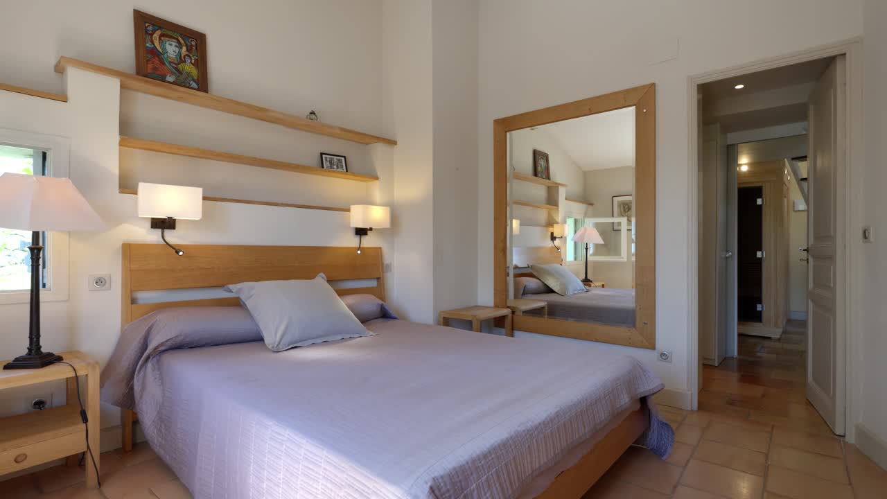 Slow establishing shot of a modern master bedroom with wooden accents