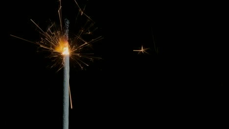 christian sparklers, bengal lights on black background. firework sparkler burning on dark background. closeup