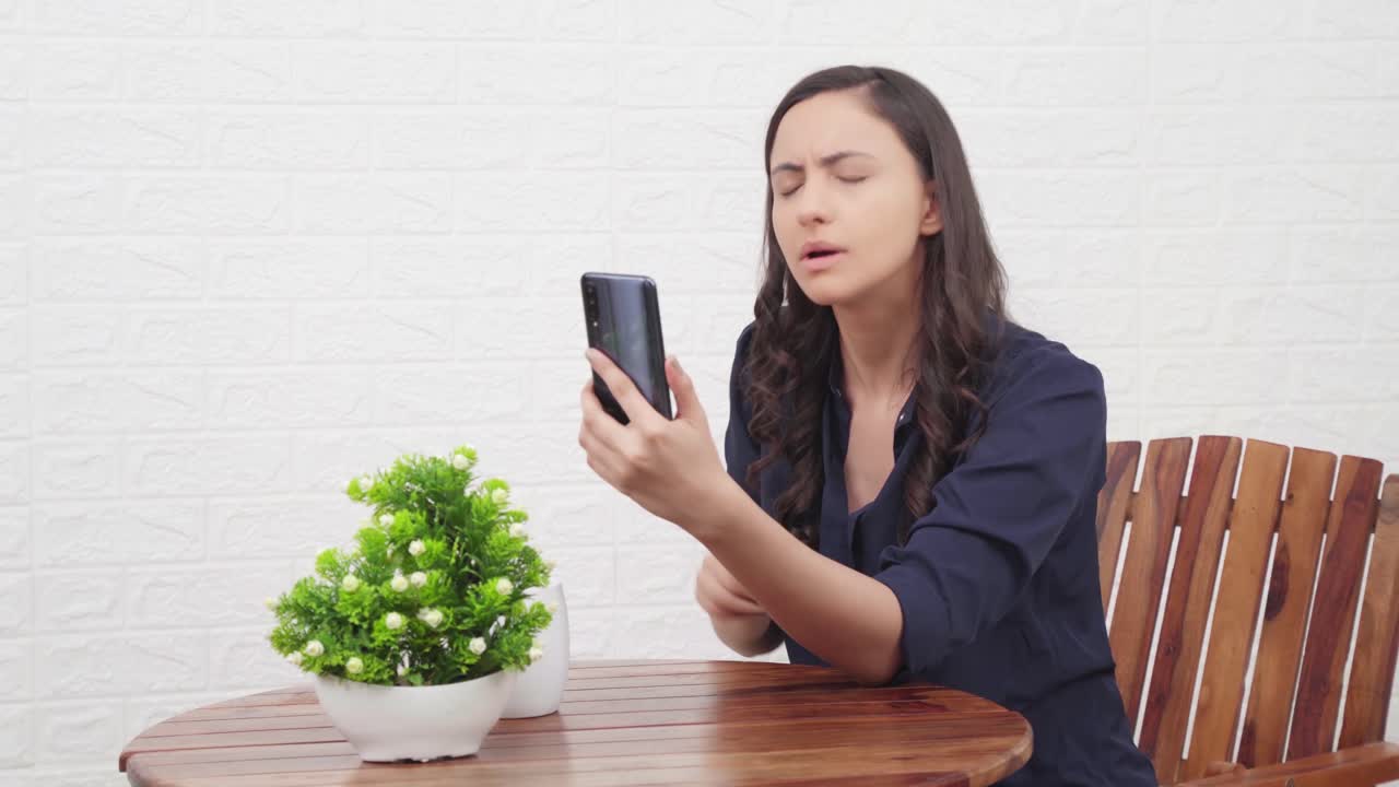 화난 인도 소녀 가 비디오 통화 로 누군가 와 대화 하고 있다