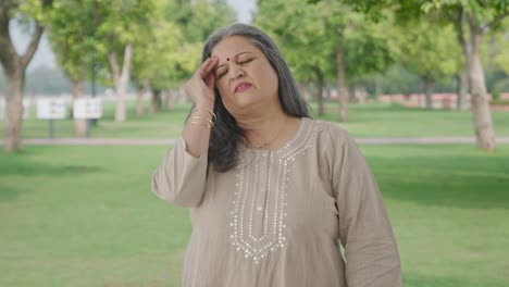 Sick-Indian-old-woman-suffering-from-a-headache-in-park