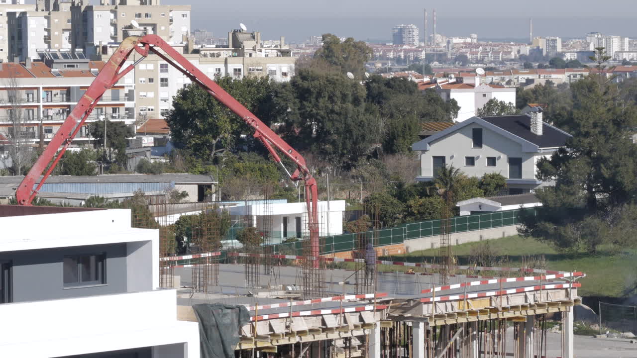 plano general estático que muestra el sitio de construcción con grúa y trabajadores en la azotea de un nuevo edificio moderno