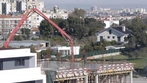 static wide shot showing construction site with crane and workers on the rooftop of a new modern building