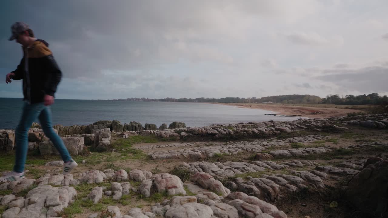 joven alto da vueltas y camina de vuelta en vårhallarna sur de suecia - plano general estático