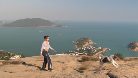 wide shot of girl walking with dog on dragons back trail, hong kong