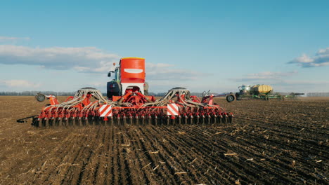 Steadicam-Shot:-Two-Tractors-With-Seeders-Sow-Wheat-On-The-Field-In-Early-Spring-1