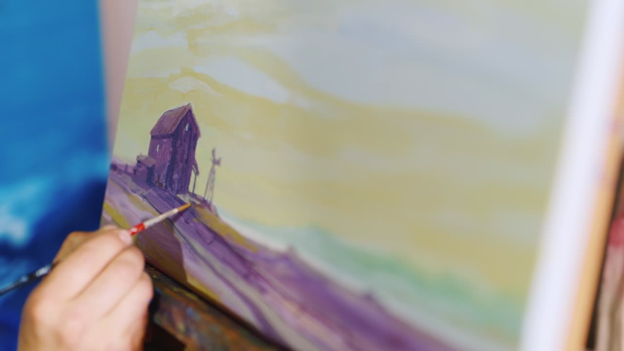 la mano del artista dibuja una imagen, la pintura es un paisaje rural típico: un campo y un granero