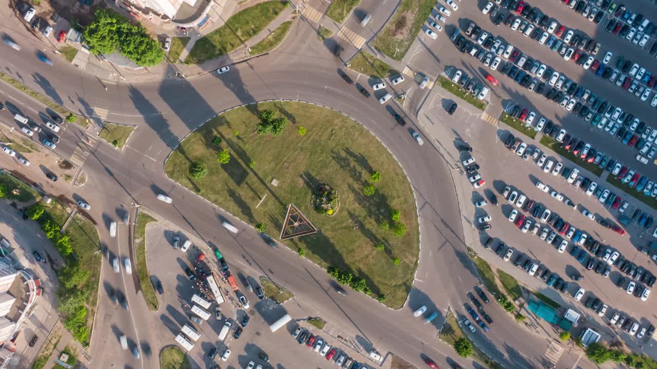 vista aérea de una intersección de la ciudad ocupada con rotonda y estacionamiento