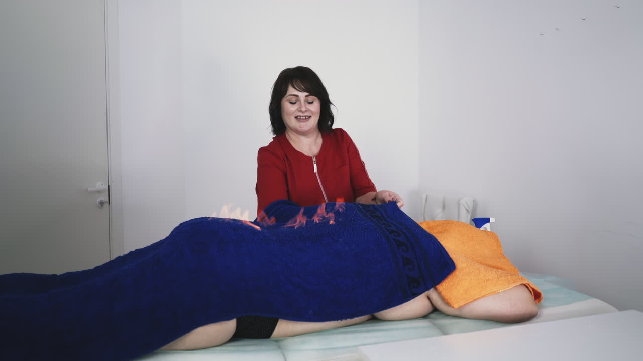 치료사는 환자의 등 위에 불타는 수건  ⁇ 에 손을  ⁇ 습니다.