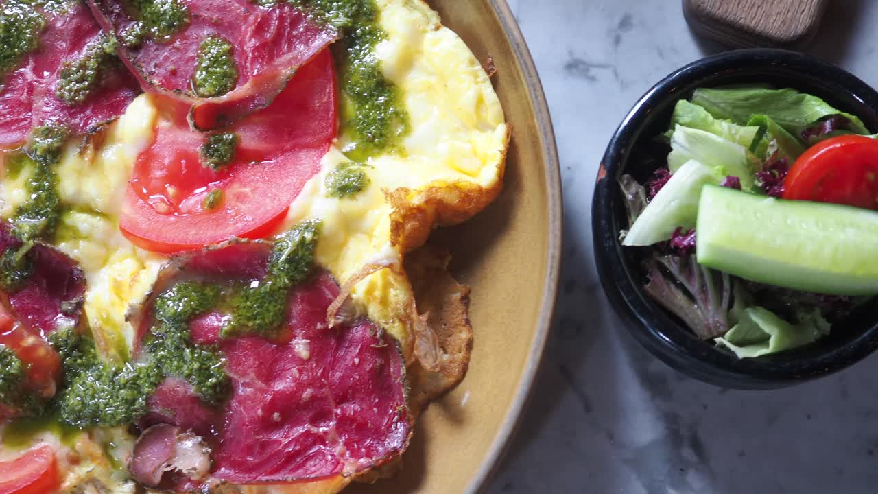 Omelet with meat, tomato, and pesto