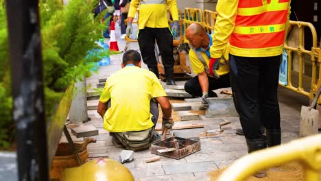 trabajadores que reparan el pavimento en la ciudad de hong kong