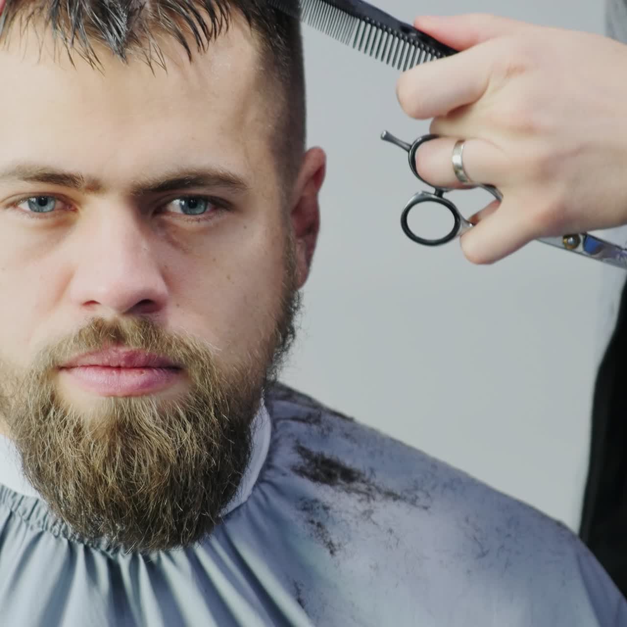 Mand får klippet hår i barbersalon