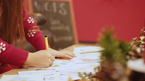 young girl coloring at a table