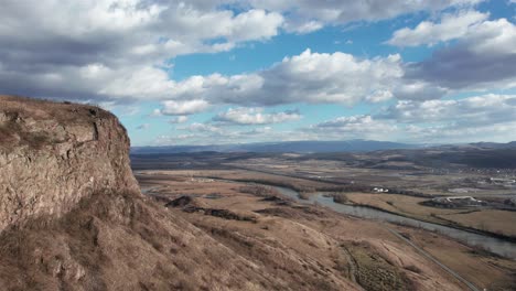 aerial dolly shot, passing a cliff over the endless romanian landscape at the end of winter