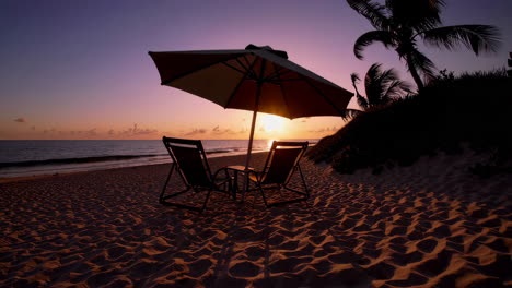 beach chairs and umbrella at sunset