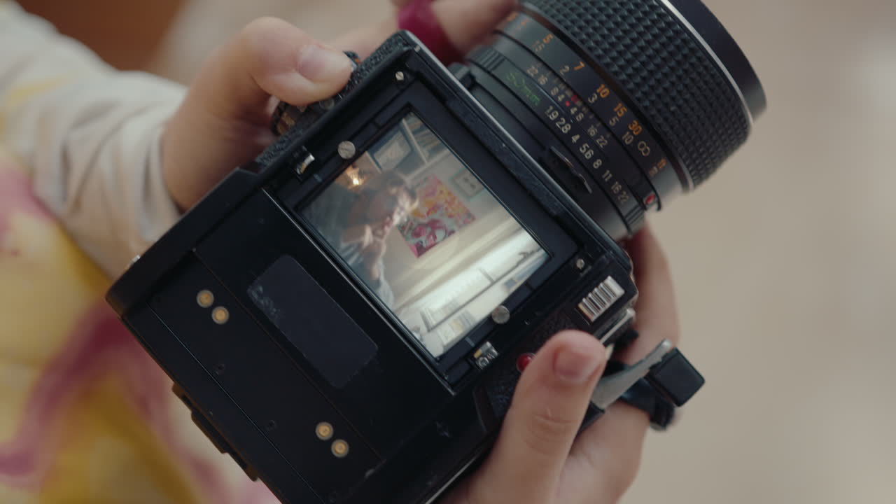 Hands of Girl Holding Camera and Photographing Boyfriend at Home