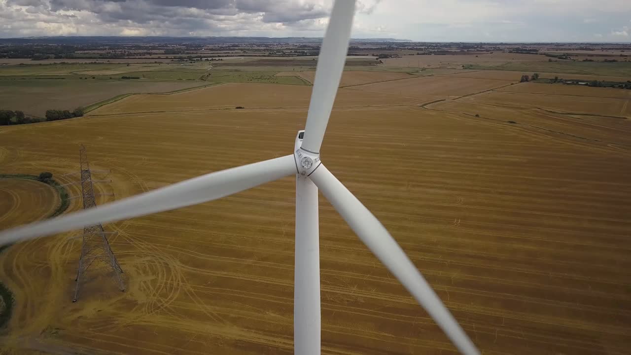 Aerial closeup view of wind turbine pedestal tilt down shot