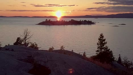 flying over smooth granite rock at sunset, drone aerial wide dolly in