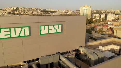 aerial view of a modern building complex with parking lot and cityscape