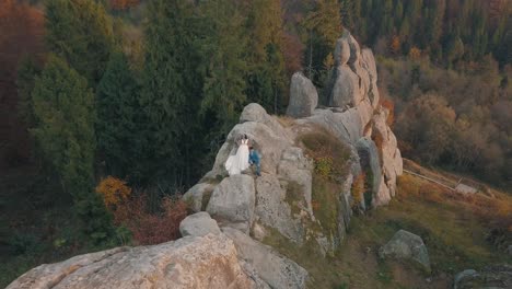 newlyweds stand on a high slope of the mountain. groom and bride. arial view