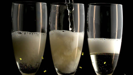 Animation-of-gold-confetti-falling-over-champagne-pouring-into-three-glasses-on-black-background