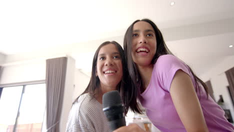 singing karaoke, two teenage girls smiling and enjoying their hangout