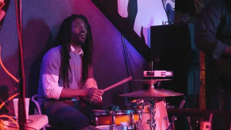 atlanta, ga - december 15, 2018: a drummer plays with energy and passion during an exciting rap and hip hop concert in an underground urban nightclub popular with millennials.