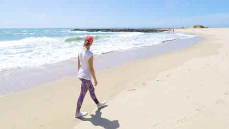 Mujer-Joven-Caminando-En-Una-Playa-En-La-Costa-Oeste,-EE.UU.