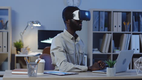 young office worker wearing a vr headset, scrolling and taping in the air in the office at night