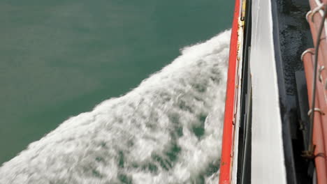 Portside-view-of-ferry-creating-wake-across-water