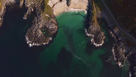 vestarelen beach with clear turquoise water and surrounding rocky landscape, aerial view