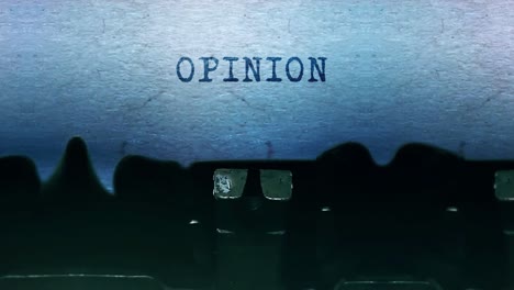 Opinion word closeup being typing and centered on a sheet of paper on old vintage typewriter