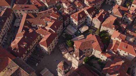 Golden-hour-sunlight-on-Kotor-City-center-with-Cathedral,-aerial