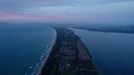 Tonos-Crepusculares-Sobre-Un-Tranquilo-Paisaje-Costero-Con-Suaves-Olas,-Vista-Aérea