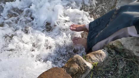person's feet in a stream